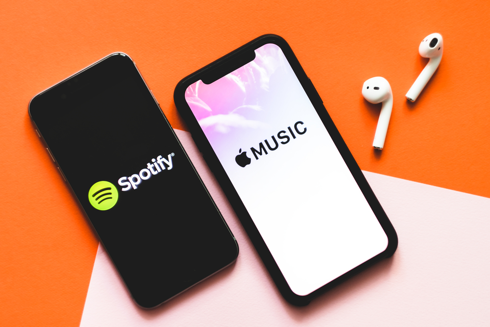 iPhone X with Screen shot of Apple music app and Spotify.